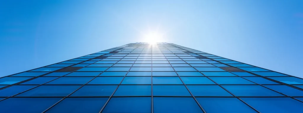 a towering, modern commercial building under a clear blue sky showcases a newly installed roof, symbolizing compliance with local building codes and the importance of safety in roofing practices.